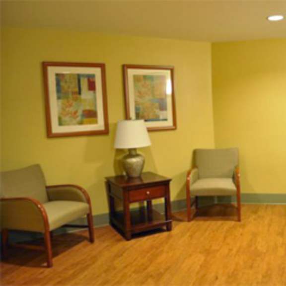 a living room with chairs and paintings on the wall