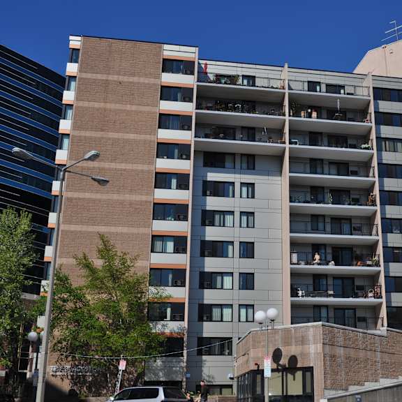 an image of a tall building with balconies in a city