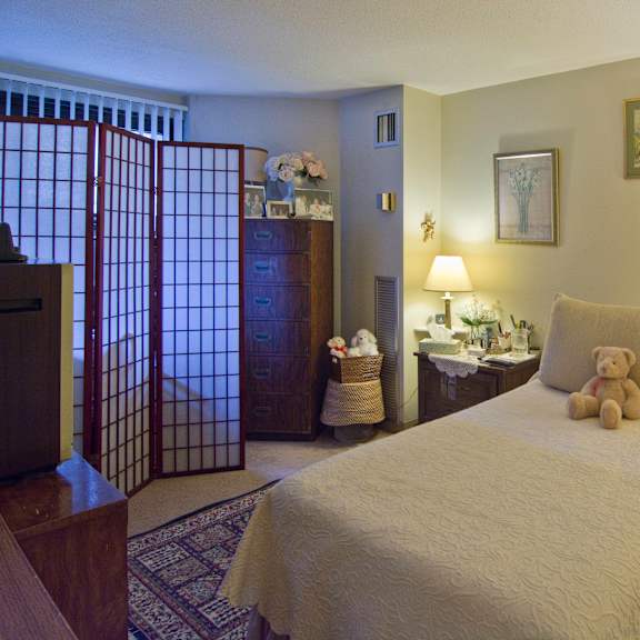 a bedroom with a bed and a teddy bear