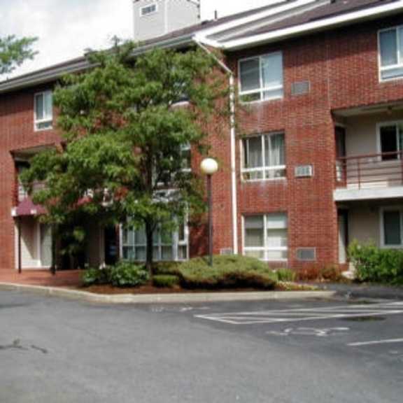 a red brick apartment building with a parking lot