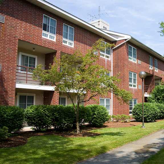 a brick apartment building with a sidewalk in front of it