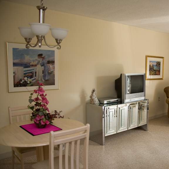 a living room with a tv and a table and a chair