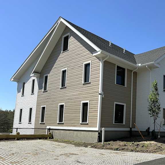 the exterior of a white house with a gray roof