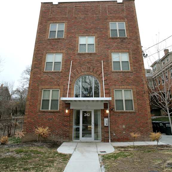 the front of a brick building with a sidewalk in front