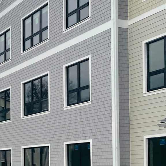 a large building with multiple windows and a grey roof.