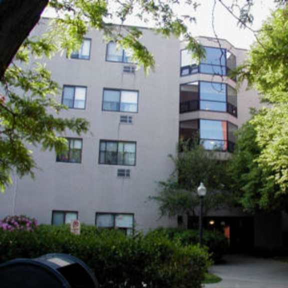 an apartment building with trees in front of it