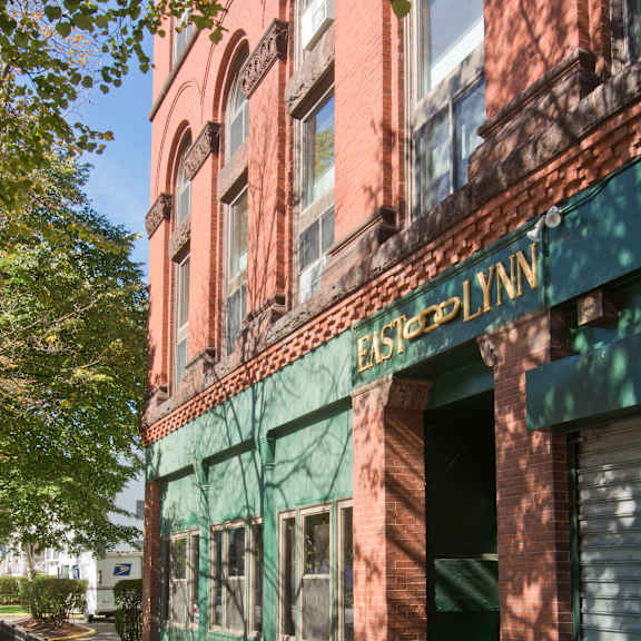 an old building with a green facade and a sidewalk