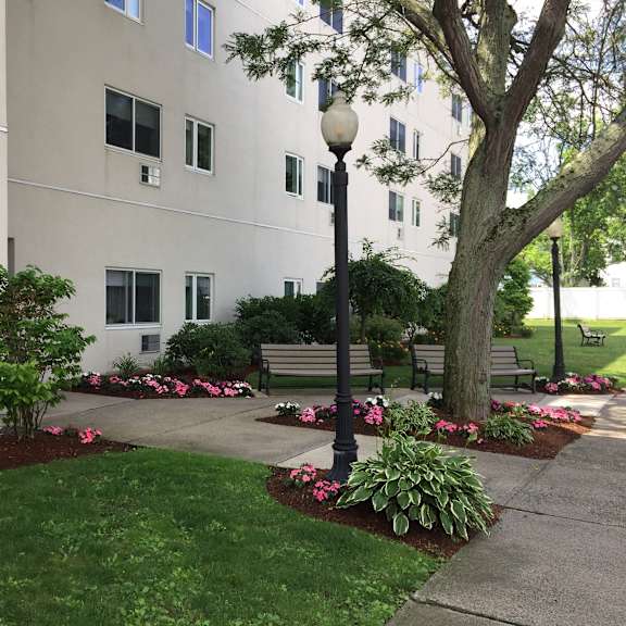 a courtyard with benches and trees in front of a building