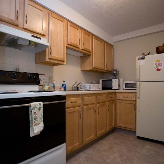 a kitchen with white appliances and wooden cabinets