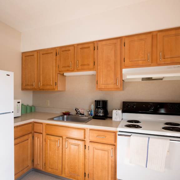 a kitchen with white appliances and wooden cabinets