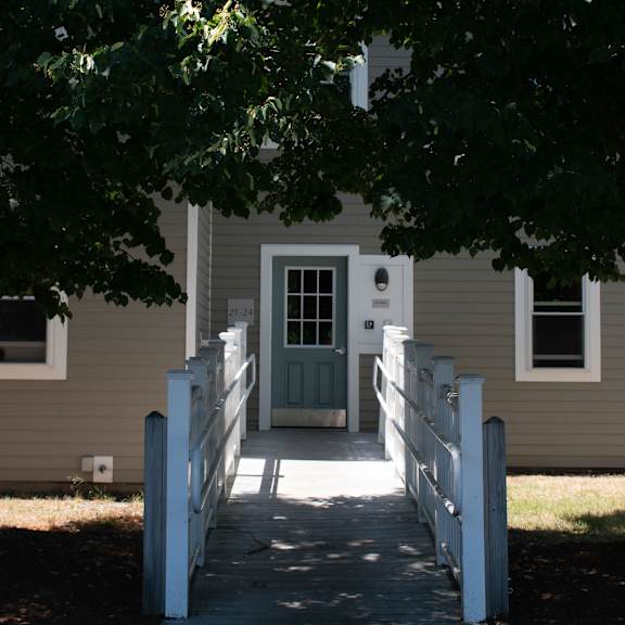 a white house with a white walkway and a green door