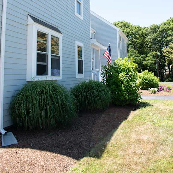 a blue house with an flag in the front yard