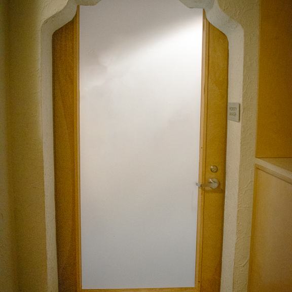 a door in a room with a white wall