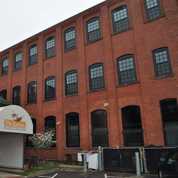 a red brick building with a sign in front of it