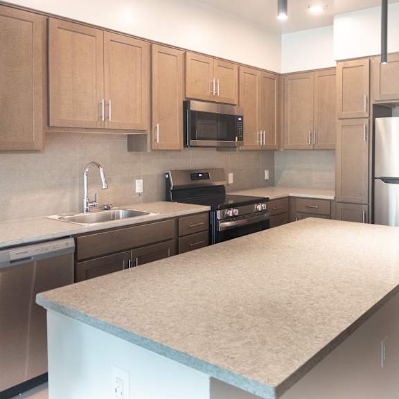 a kitchen with a refrigerator, sink, and microwave.