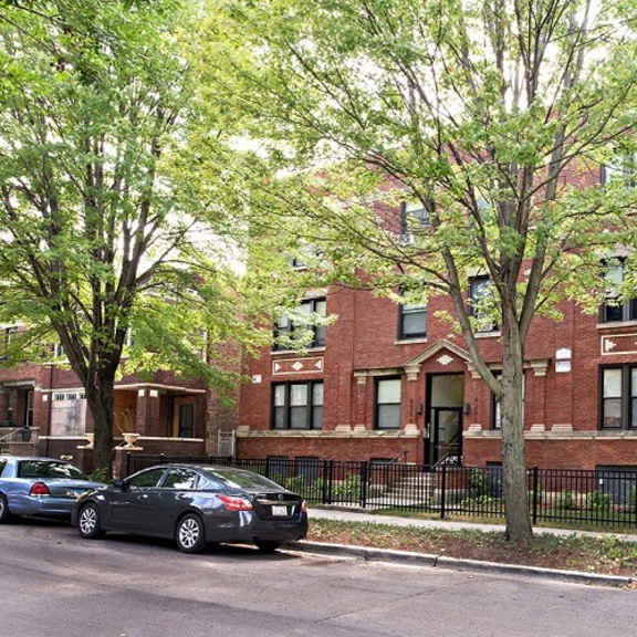 a red brick building with cars parked in front of it