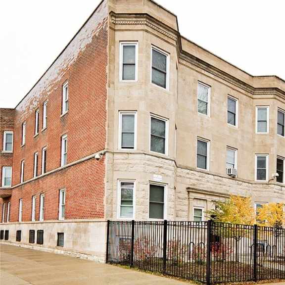 a large brick building with a fence in front of it