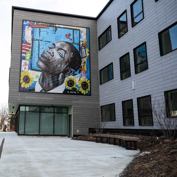 a mural of a man with flowers is on the side of a building.