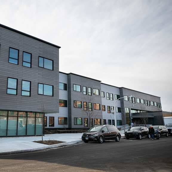 a modern building with a parking lot in front.