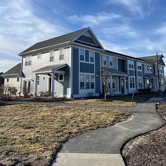 a blue house with a sidewalk in front of it