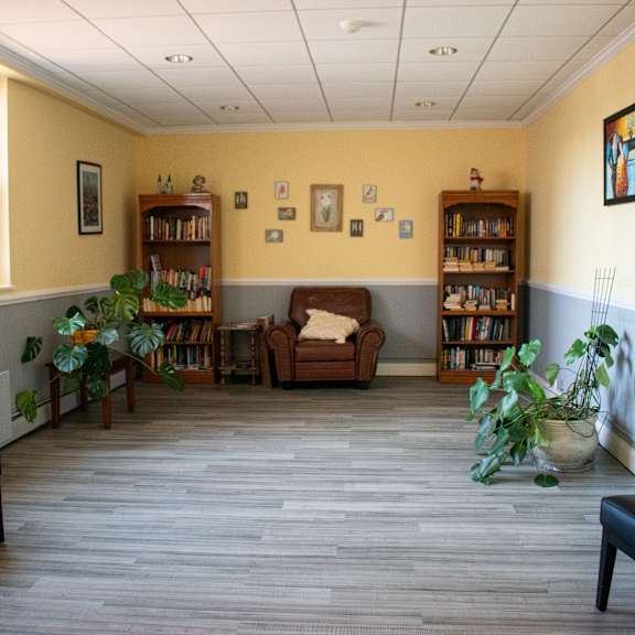 the waiting room of a physicians office with chairs and plants