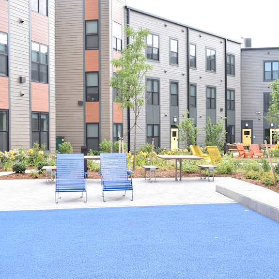 a blue court yard with chairs and tables in front of buildings