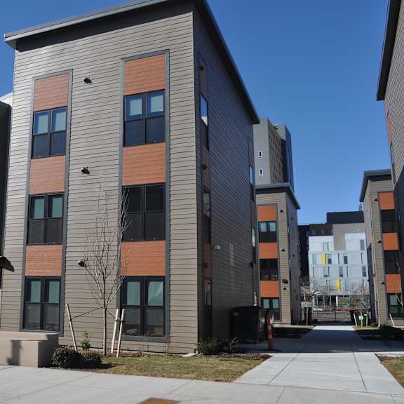 a new apartment building on the corner of a sidewalk