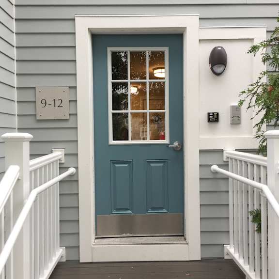 a tiny house with a blue door and a staircase