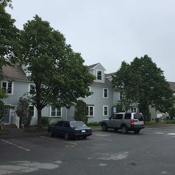 a parking lot with cars in front of houses