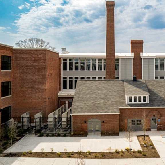 a large brick building with a smaller brick building in front of it.