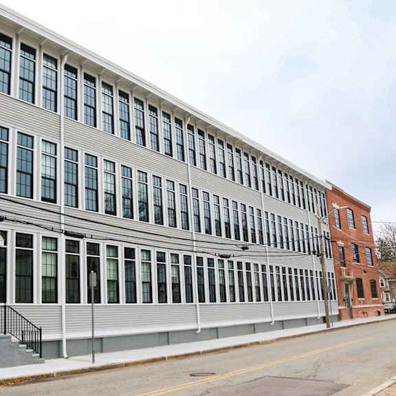 a grey building with a black railing in front.