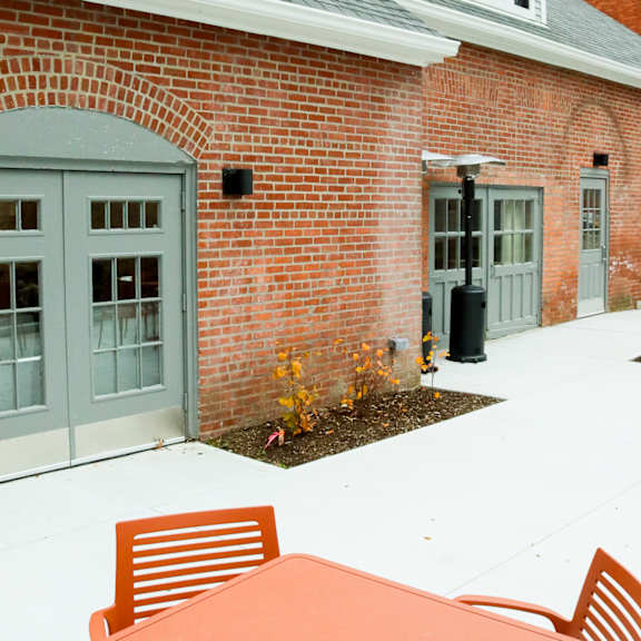 a red brick building with a grey roof and a white door.