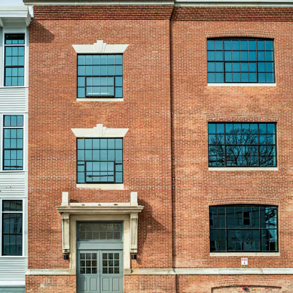 a red brick building with a grey door and windows.