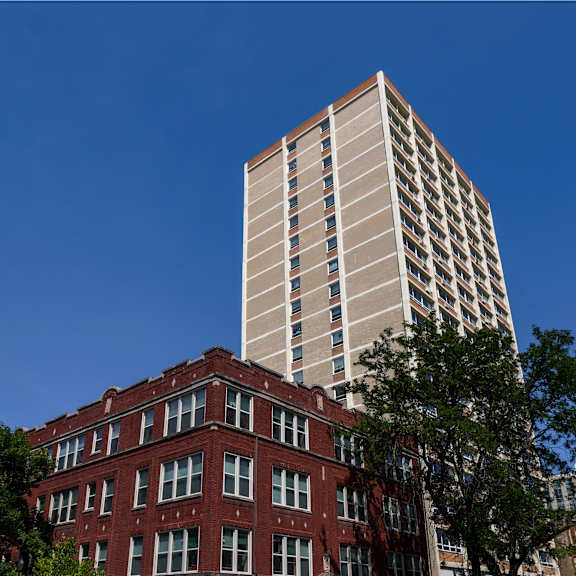 a red brick building with a tall white building behind it.