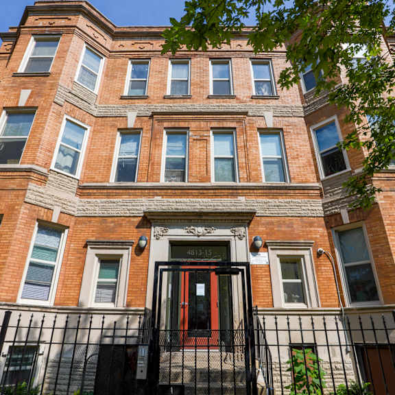 a red door is on the front of a brick building.