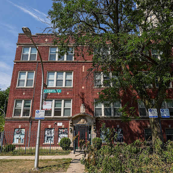 a red brick building with a tree in front of it.