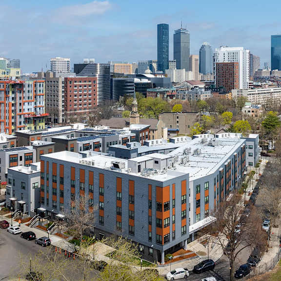 a cityscape with a baseball field in the foreground.