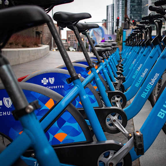 a row of blue bikes are parked next to each other.