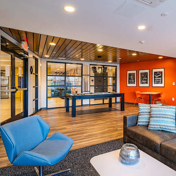 a living room with a blue chair and a brown couch.