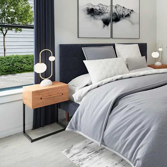 a bedroom with a large bed and two artworks on the wall.