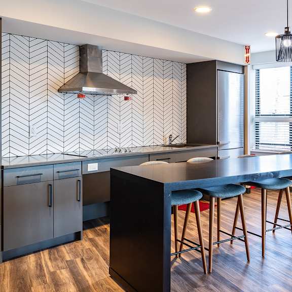 a kitchen with a black counter top and bar stools.