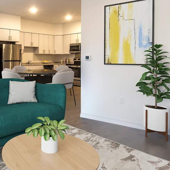 a living room with a green couch, a table with a plant on it, and a painting on the wall.