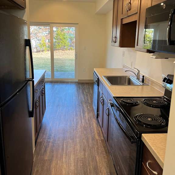 a kitchen with stainless steel appliances and wooden floors