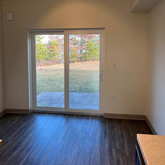 a living room with a large window and a wooden floor