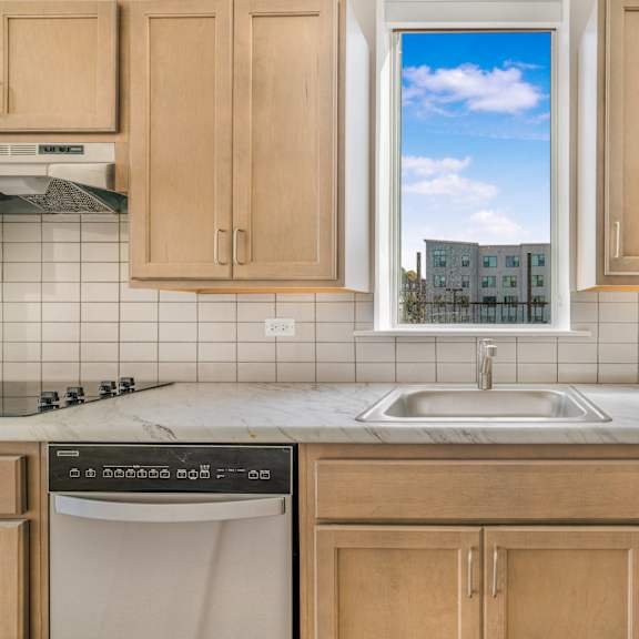 a kitchen with wooden cabinets and a window over the sink