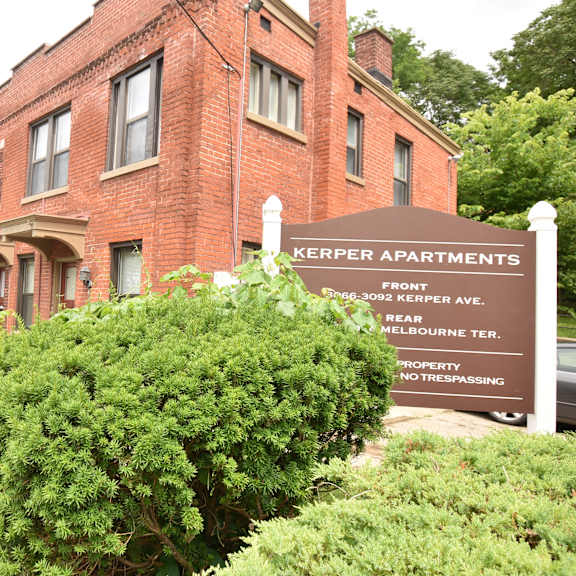 a sign for kepler apartments in front of a brick building