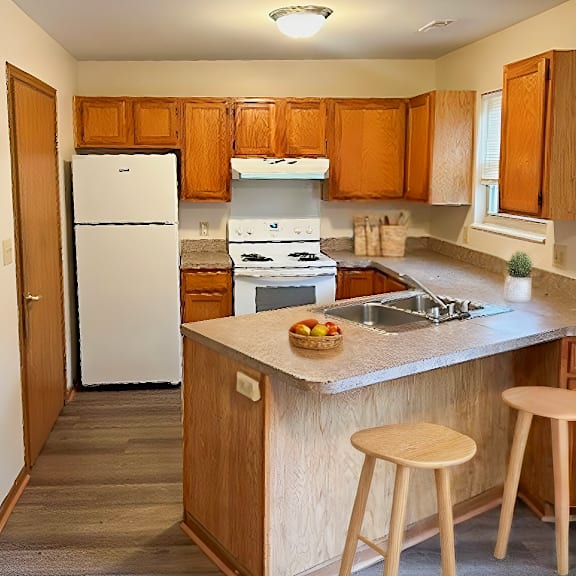 a kitchen with a white fridge and wooden cabinets.