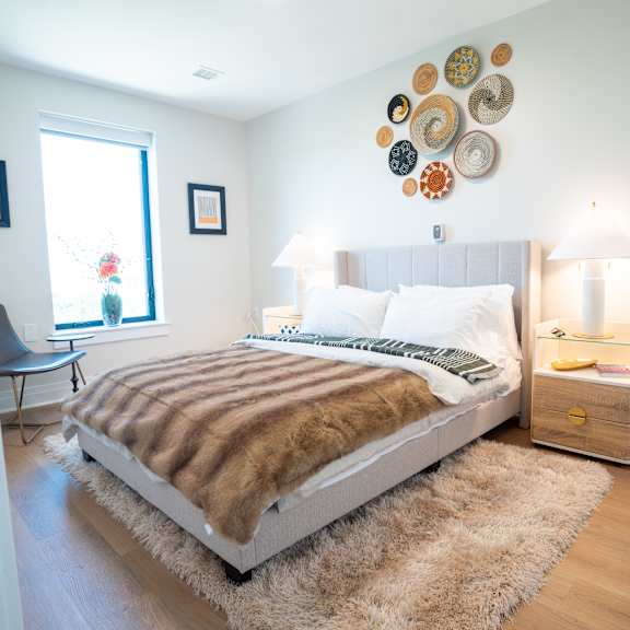 a bedroom with a bed and several plates on the wall