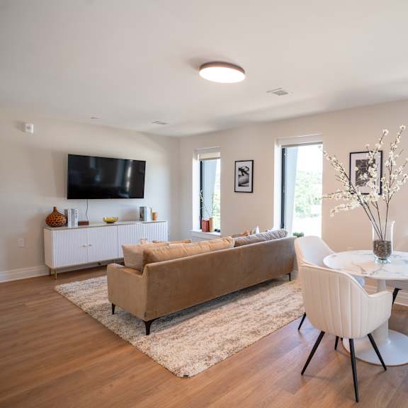 a living room with a couch table and chairs and a tv