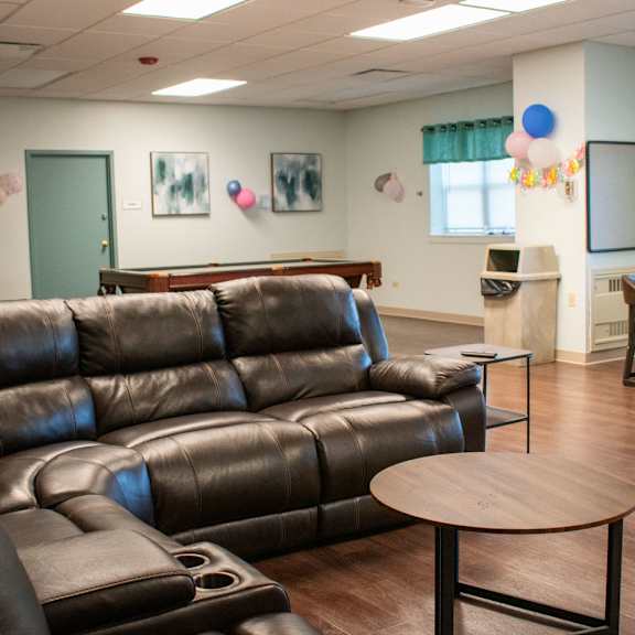 a living room with couches and a table and chairs and a projection screen